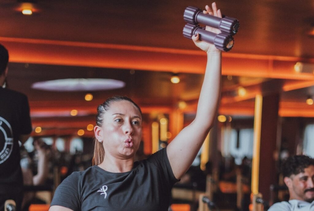 Alumna de Club Fito Fitness entrenando con mancuernas durante una sesión acompañada